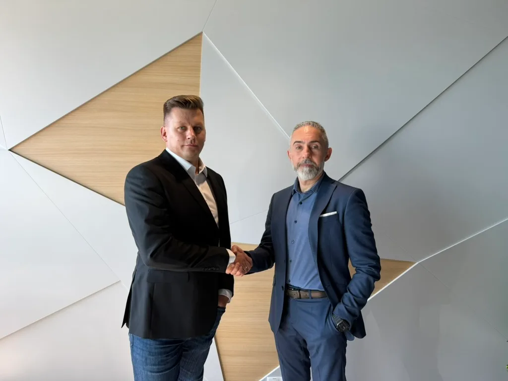 Łukasz Jesis, CEO and Founder of Xopero Software, and Tomasz Bartel, CEO and Founder of Vigil Guard, shaking hands.